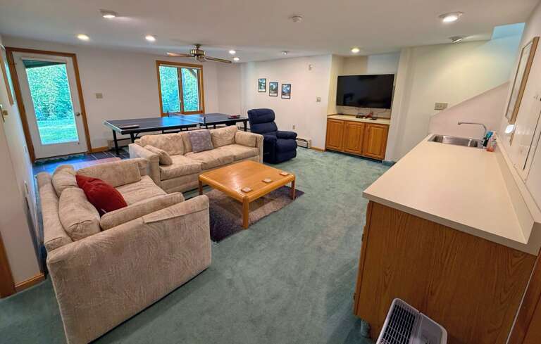 Lower level living space with large TV, Ping Pong Table, wet bar, and walkout to shared yard and grill. Lower level living space with large TV, Ping Pong Table, wet bar, and walkout to shared yard and grill.