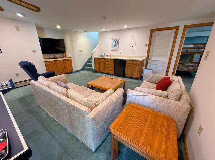 Lower level living space with large TV, Ping Pong Table, wet bar, and walkout to shared yard and grill. Lower level living space with large TV, Ping Pong Table, wet bar, and walkout to shared yard and grill.