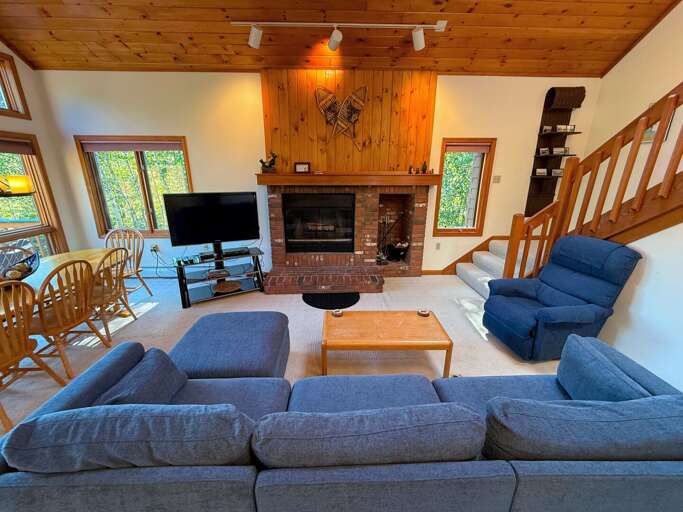 Main level living area with wood fireplace, TV with cable, and walkout to main level deck - adjacent to dining area and kitchen. Main level living area with wood fireplace, TV with cable, and walkout to main level deck - adjacent to dining area and kitchen.