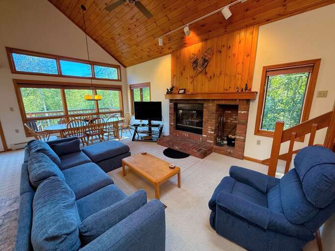 Main level living area with wood fireplace, TV with cable, and walkout to main level deck - adjacent to dining area and kitchen. Main level living area with wood fireplace, TV with cable, and walkout to main level deck - adjacent to dining area and kitchen.