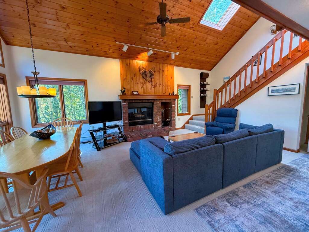 Main level living area with wood fireplace, TV with cable, and walkout to main level deck - adjacent to dining area and kitchen. Main level living area with wood fireplace, TV with cable, and walkout to main level deck - adjacent to dining area and kitchen.