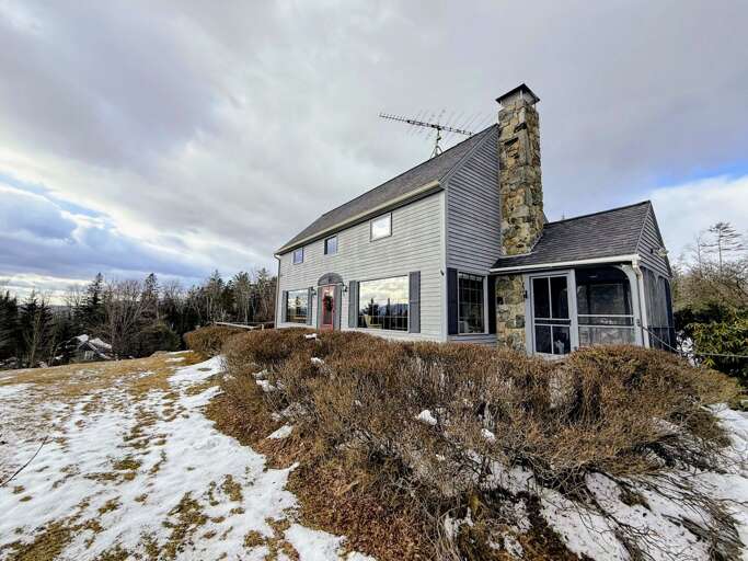 Stone-chimneyed Structure Standing On Snowy Slope Under Cloudy Skies