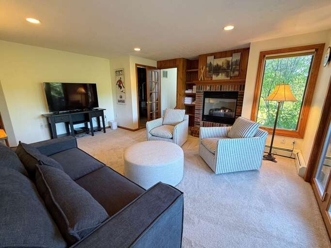 Lower level living area is spacious and offers a large TV, gas fireplace, and a walkout to the hot tub, yard, and ski access.