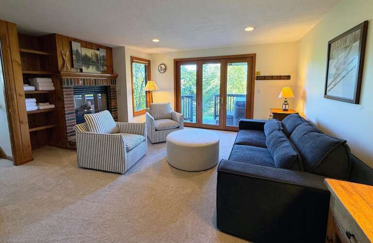 Lower level living area is spacious and offers a large TV, gas fireplace, and a walkout to the hot tub, yard, and ski access.
