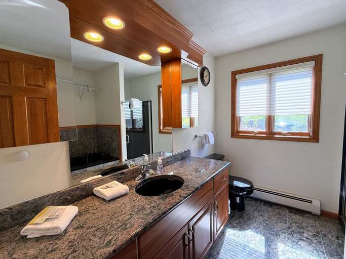 Main Level King Bedroom Ensuite Bath boasts granite countertops and both a shower and jetted tub.