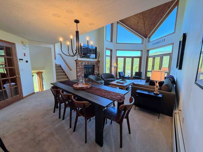 The main living room boasts mountain views, a gas fireplace and TV and is an open layout with the dining and kitchen areas.