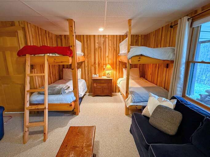 Lower level sitting area doubles as sleeping space with 2 custom-built bunk beds, Lower level sitting area doubles as sleeping space with 2 custom-built bunk beds,