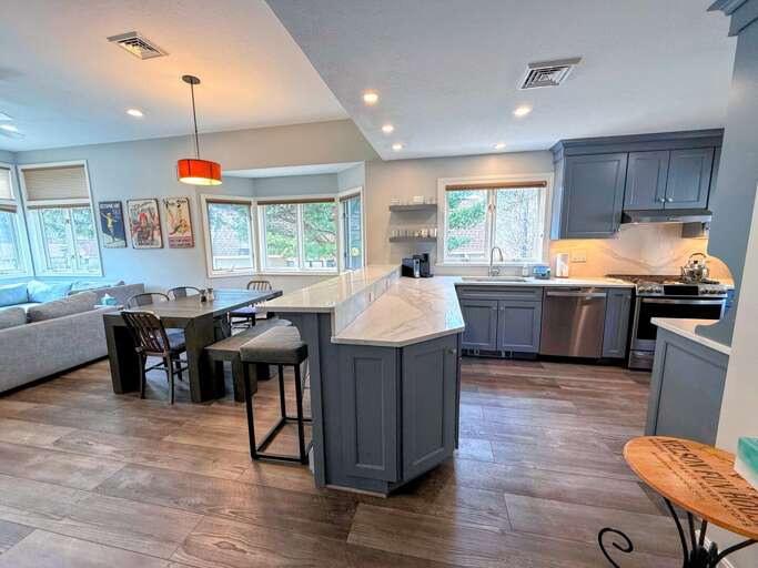 The fully stocked kitchen with a cozy breakfast bar flows seamlessly into the dining and living areas The fully stocked kitchen with a cozy breakfast bar flows seamlessly into the dining and living areas