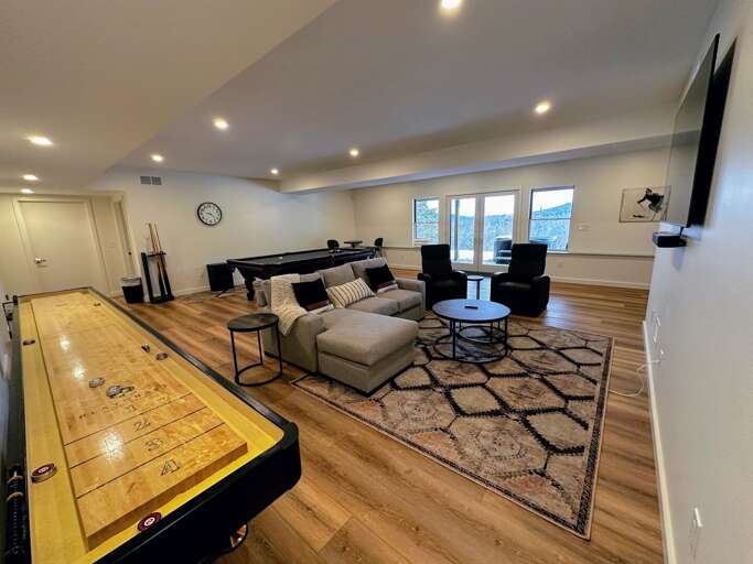 Lower Level entertainment area with a pool table, shuffleboard, and TV
