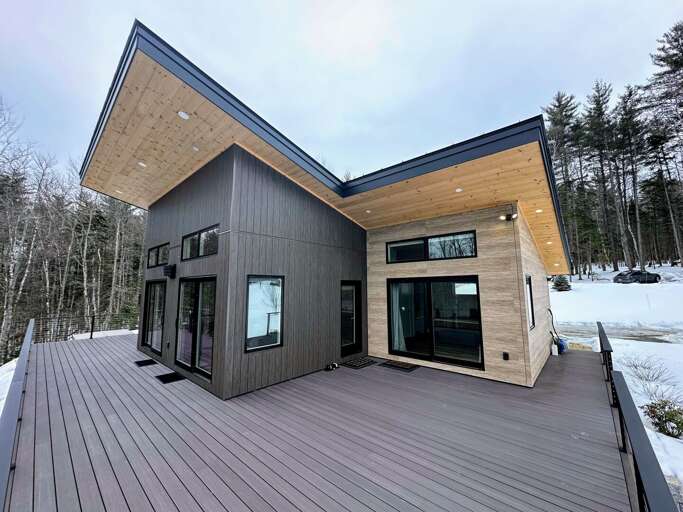 The outdoor oasis features an expansive deck, with cozy seating.