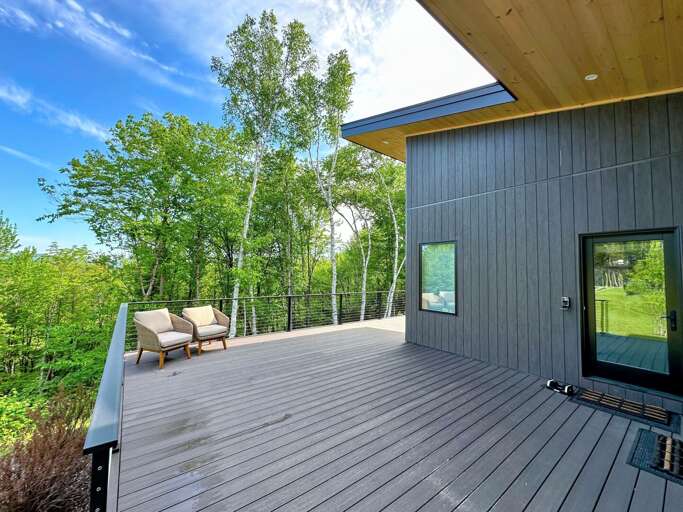 The outdoor oasis features an expansive deck, with cozy seating.