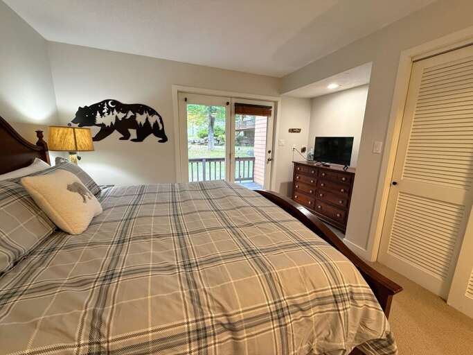 The king bedroom includes a TV, dresser, closet storage, and access to the deck.