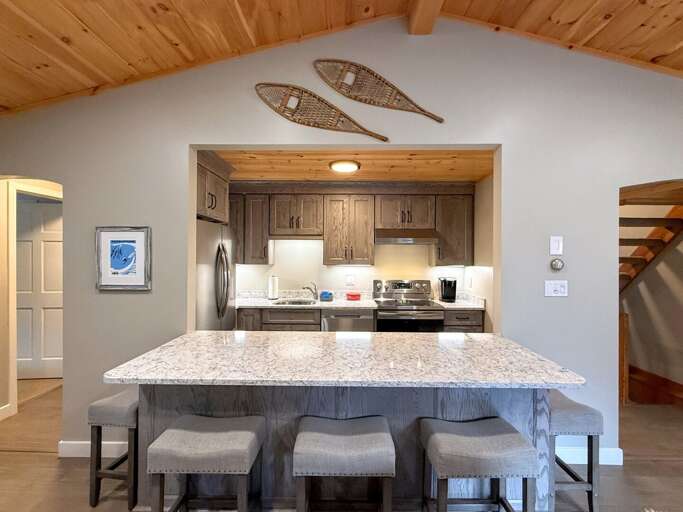 The kitchen's breakfast bar has five stools for morning coffee, quick meals, or keeping the cook company.