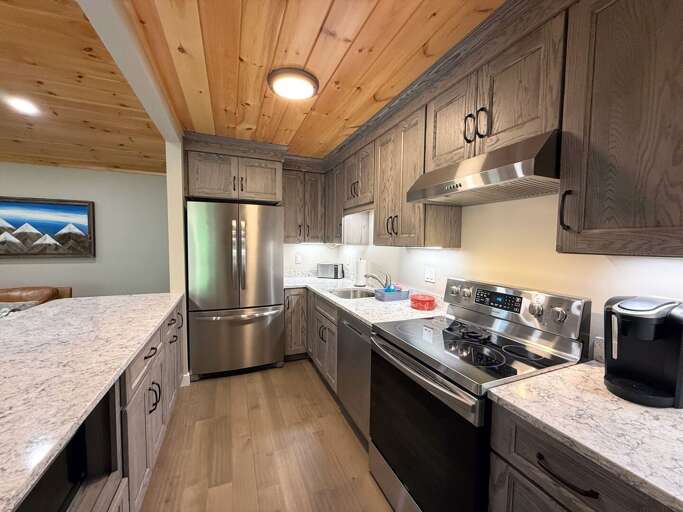 The kitchen features stainless steel appliances, granite countertops, and plenty of workspace for meals at home.