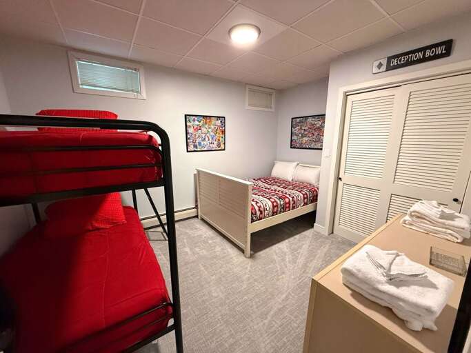 The lower-level bunk sleeping room includes a twin-over-twin bunk bed and a separate full bed.