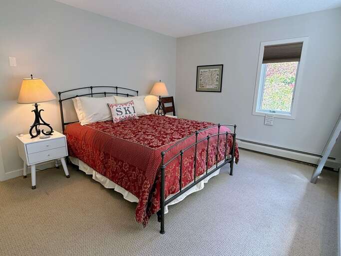The main-level queen bedroom offers bedside lighting and a restful place to recharge after mountain adventures.