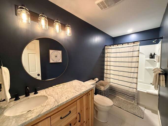 The shared main-level bathroom includes a shower/tub combination and a vanity with counter space.