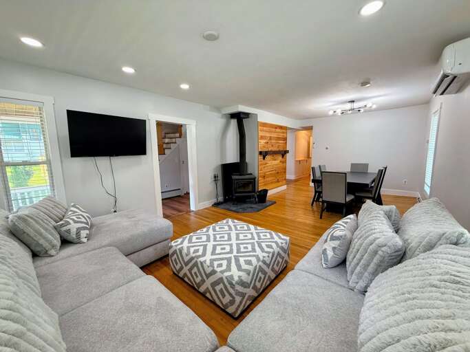 The main level living room with TV, wood-burning fireplace, and Air Conditioning Mini-Split.