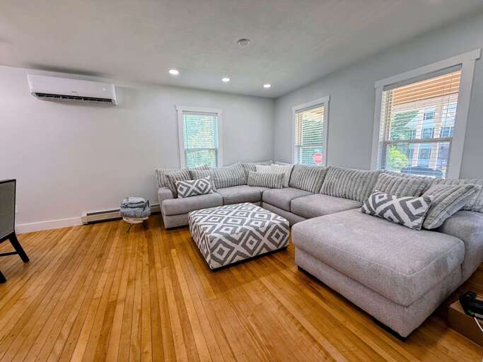 The main level living room with TV, wood-burning fireplace, and Air Conditioning Mini-Split.
