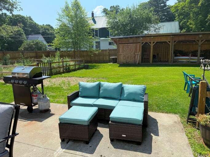 Outdoor seating and grill in the back yard.