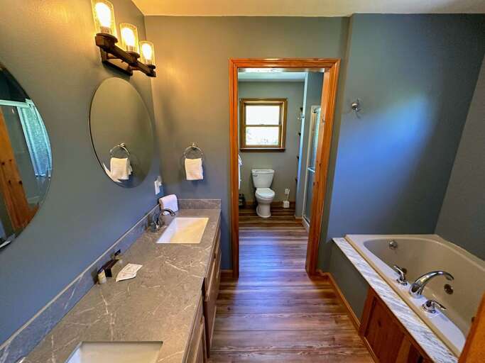 The primary bathroom includes dual sinks, a jetted tub, and a separate shower/toilet area