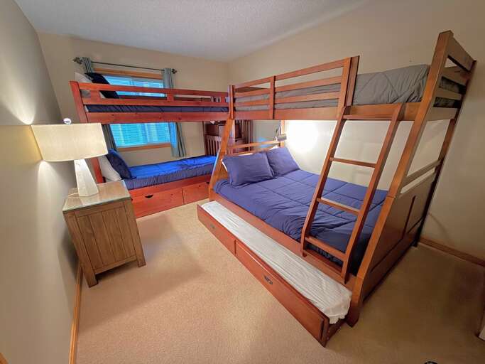 Bunk room with a twin-over-twin bunk bed, a twin-over-full bunk bed and a twin trundle