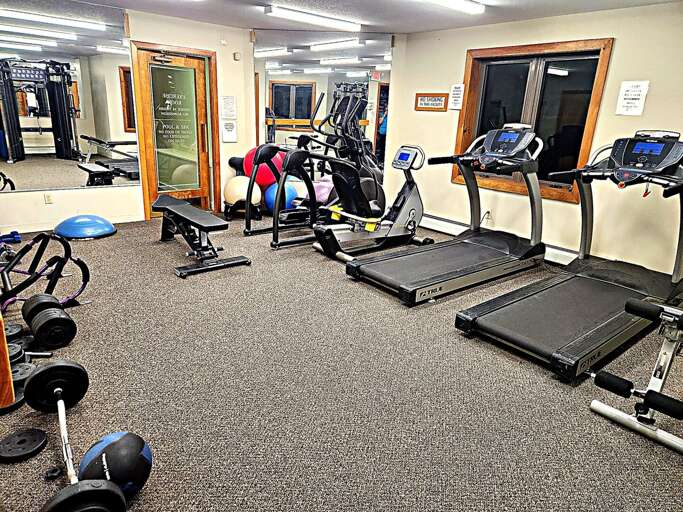 Fitness Facility With Treadmills, Weights, Mirrors, And Exercise Equipment