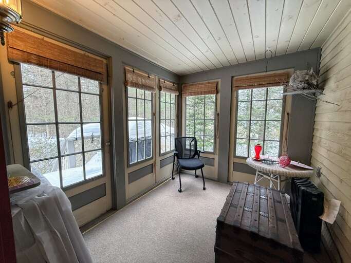 Located off of the kitchen, this screened porch is a sunny spot to enjoy and opens to the small back deck and stairs to the yard.
