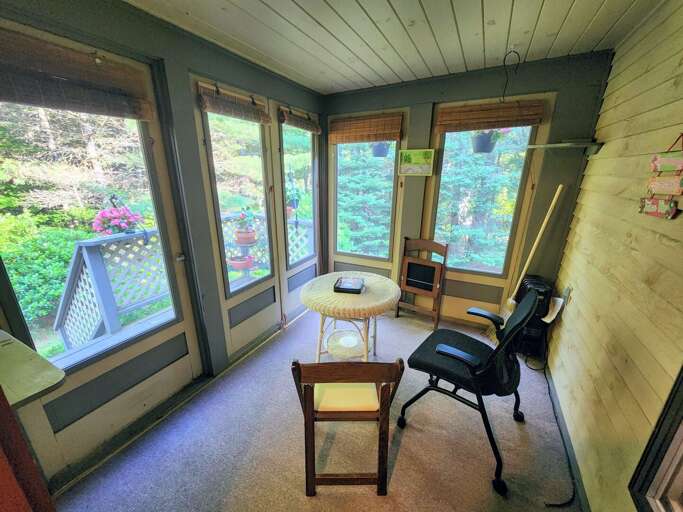 Located off of the kitchen, this screened porch is a sunny spot to enjoy and opens to the small back deck and stairs to the yard.