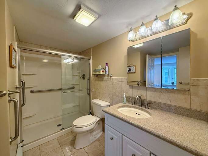 The Main Level Bathroom is equipped with a walk-in shower and two entrances - one to the main hallway and the other to the King bedroom.