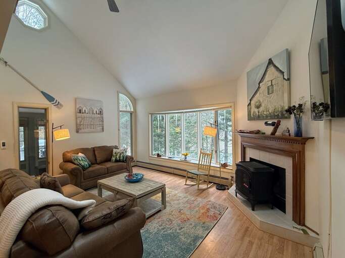 Main Level Living area sits adjacent to the dining and kitchen areas. This room offers lots of natural light, a gas stove and a smart TV.