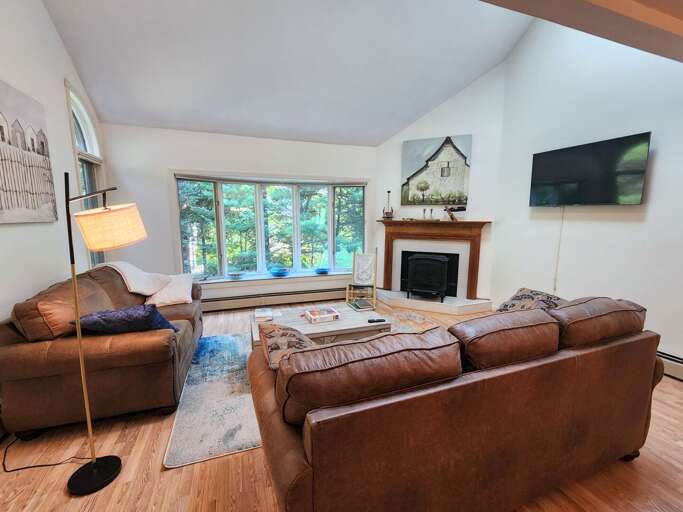 Main Level Living area sits adjacent to the dining and kitchen areas. This room offers lots of natural light, a gas stove and a smart TV.