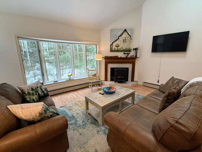Main Level Living area sits adjacent to the dining and kitchen areas. This room offers lots of natural light, a gas stove and a smart TV.