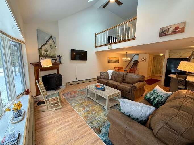 Main Level Living area sits adjacent to the dining and kitchen areas. This room offers lots of natural light, a gas stove and a smart TV.