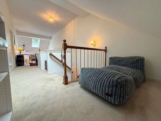 The upper level offers a small reading nook at the top of the stairs.