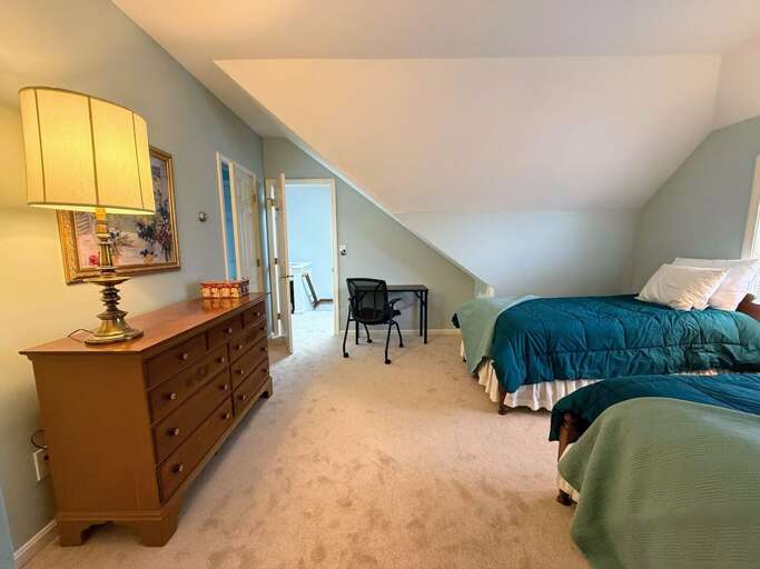 The Upper Level Twin bedroom offers two twin beds, a dresser and closet, and a desk.