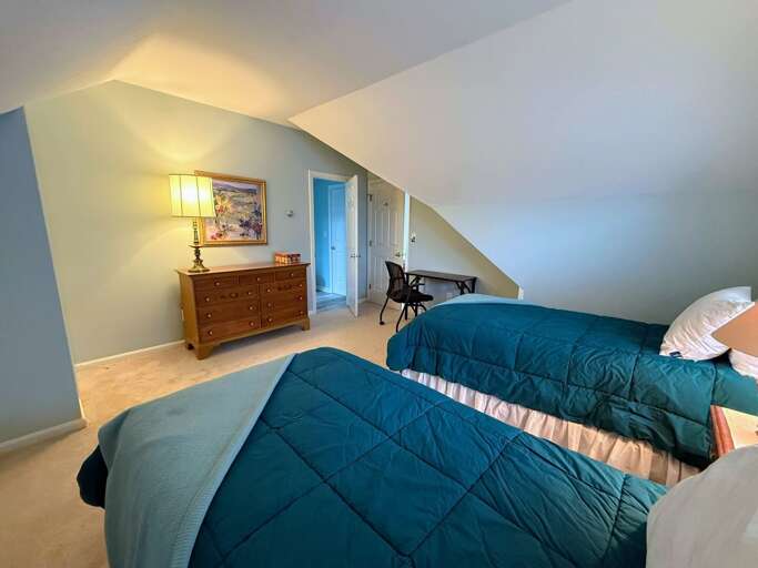 The Upper Level Twin bedroom offers two twin beds, a dresser and closet, and a desk.