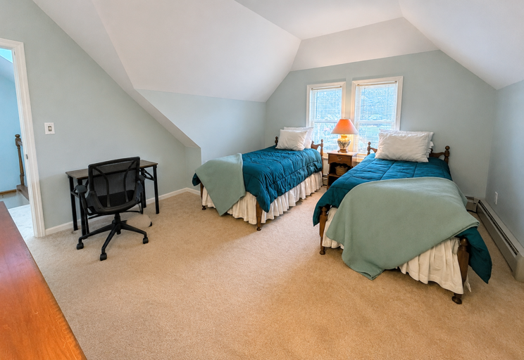 The Upper Level Twin bedroom offers two twin beds, a dresser and closet, and a desk.