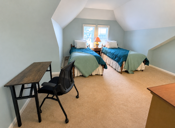 The Upper Level Twin bedroom offers two twin beds, a dresser and closet, and a desk.