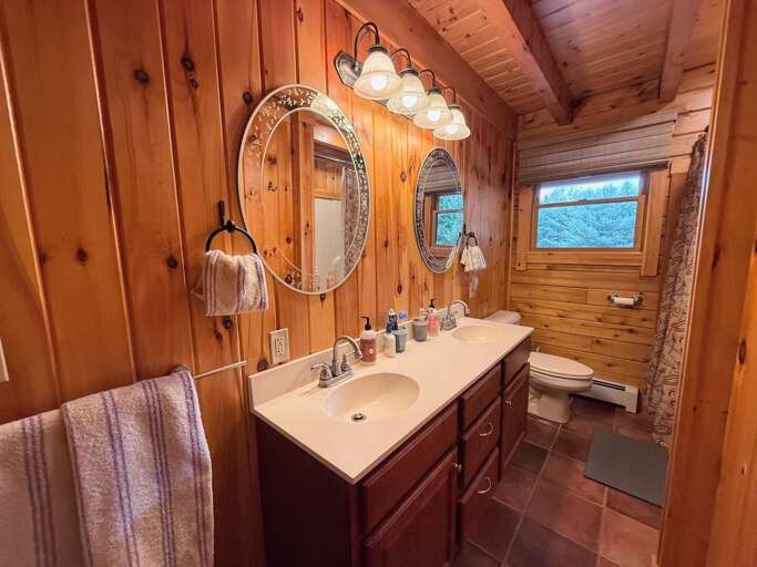 Main Level Shared Bathroom with double vanity and shower/tub combo