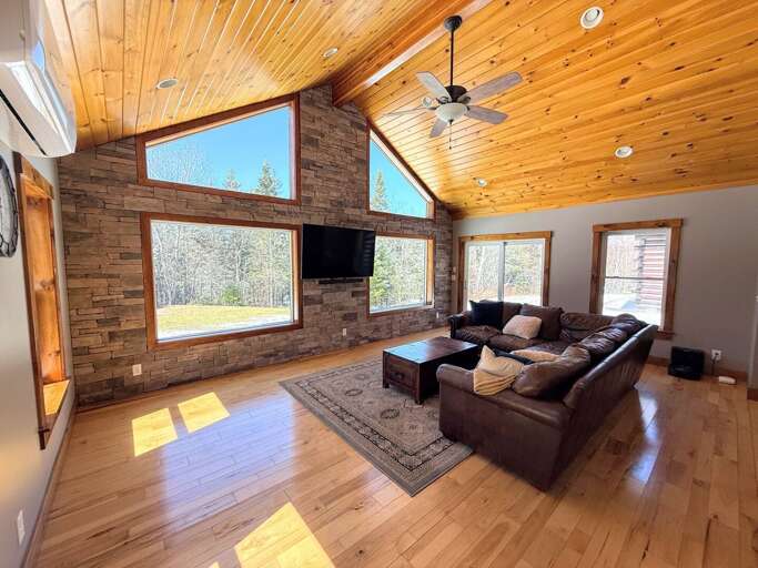 The main living area is surrounded with light and offers a comfortable leather sectional and TV