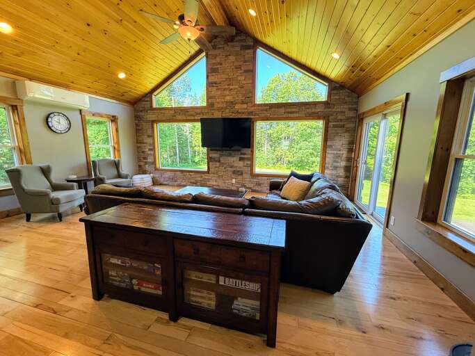 The main living area is surrounded with light and offers a comfortable leather sectional and TV