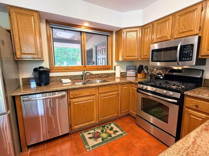 Main level kitchen offers granite countertops and stainless steel appliances.