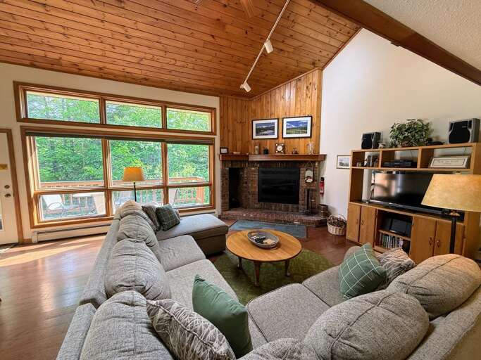 Main living space offers a comfortable sectional, wood burning fireplace, and TV.