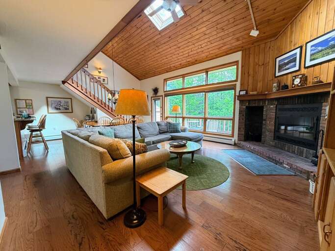 Main living space offers a comfortable sectional, wood burning fireplace, and TV.