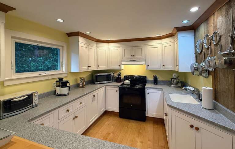 The kitchen is outfitted with standard appliances, a toaster oven, Kitchenaid mixer, and a drip coffee maker.