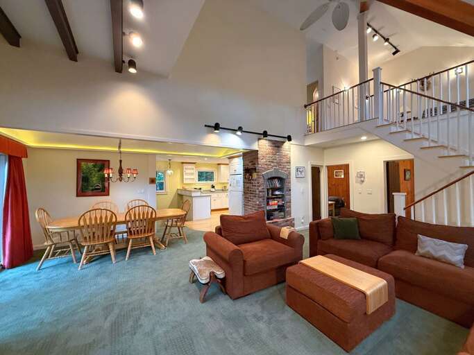 The living room boasts a comfortable sectional, wood burning fireplace, and TV.