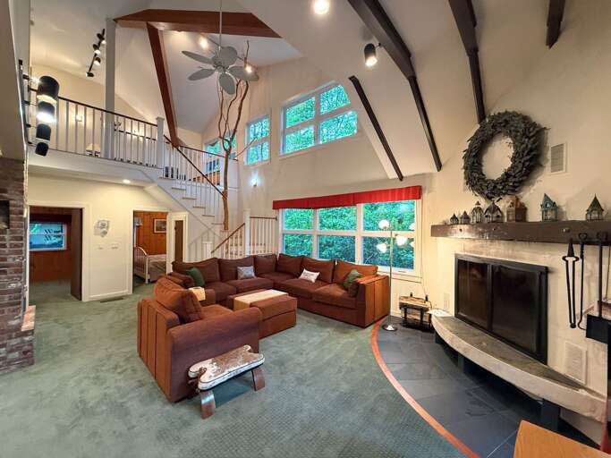The living room boasts a comfortable sectional, wood burning fireplace, and TV with two bedrooms and both bathrooms right on the main level.