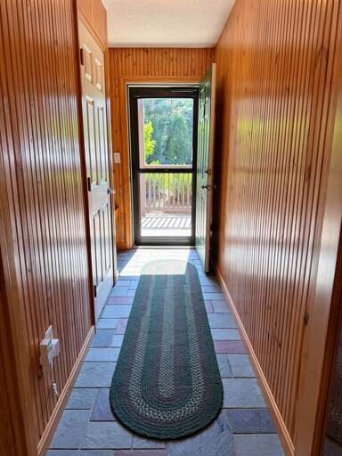 Front entryway with a bench, hooks and closet.