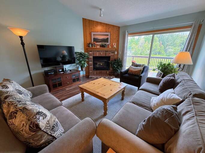 Living area with gas fireplace, comfortable seating, Smart TV, DVD player and walkout to the deck.